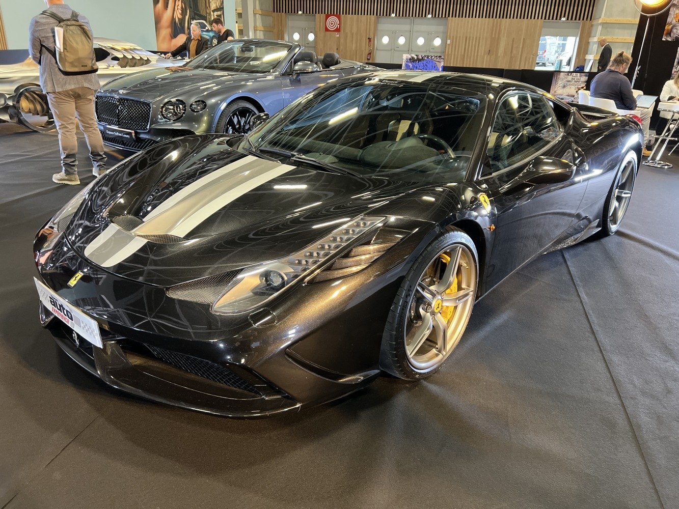 Front view of a sports car with dual racing stripes, aerodynamic shape, and alloy wheels.