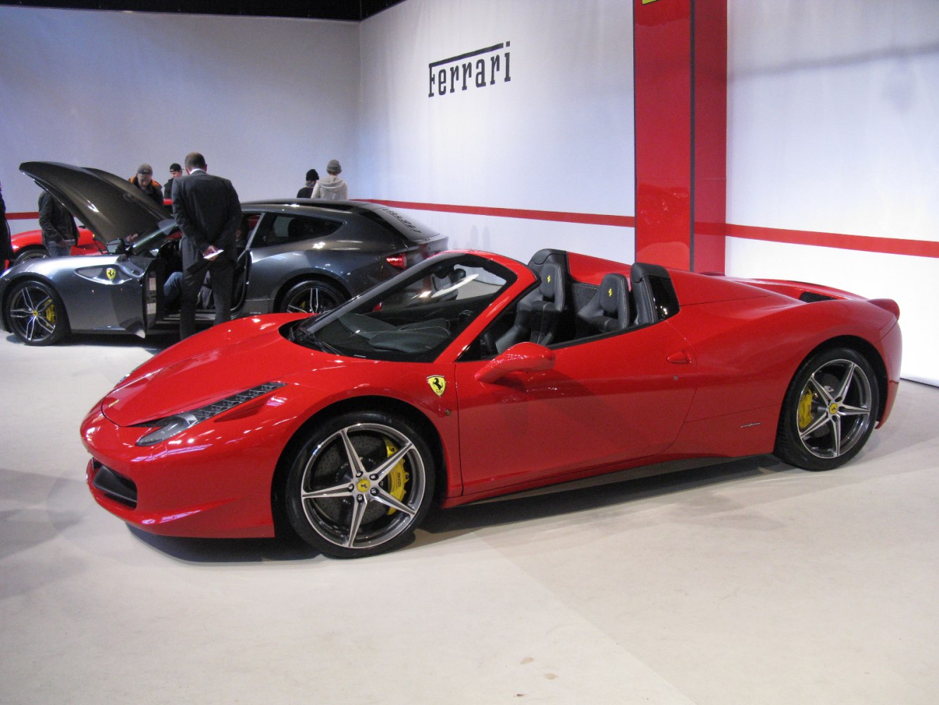 Red convertible sports car with aerodynamic shape and alloy wheels