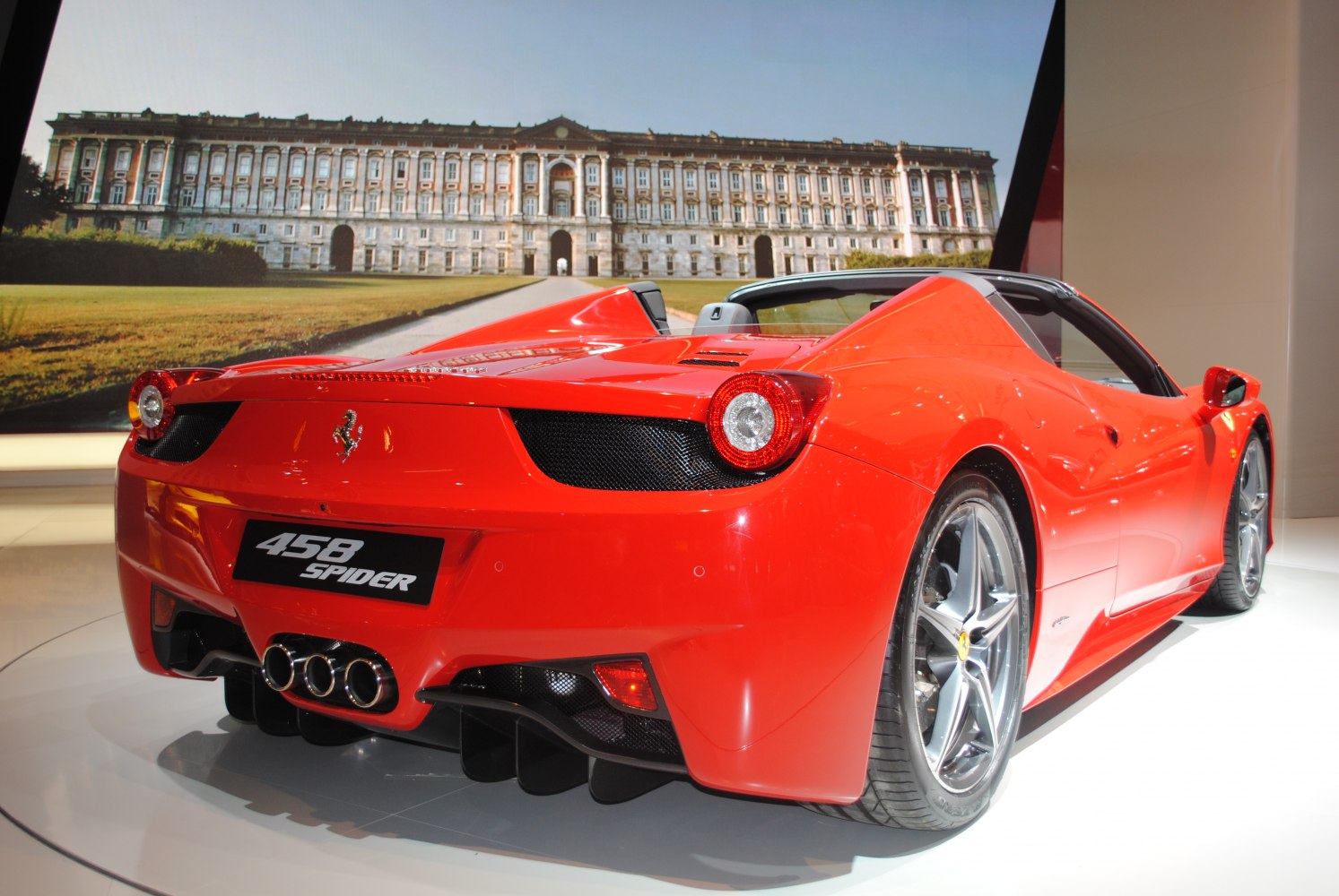 Rear view of red convertible with triple exhaust and aerodynamic design