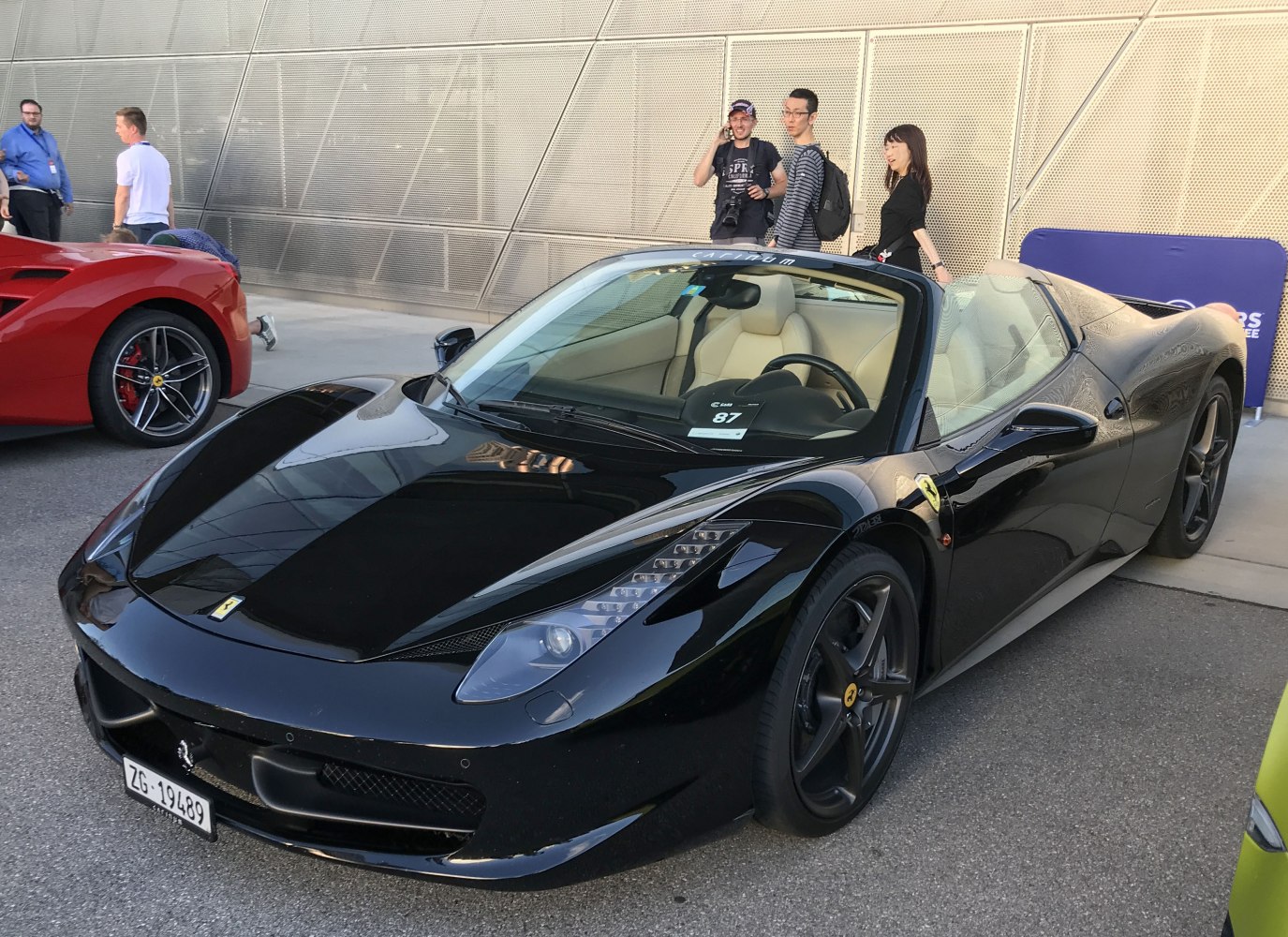 Front side view of black convertible with modern LED headlights and aerodynamic body.