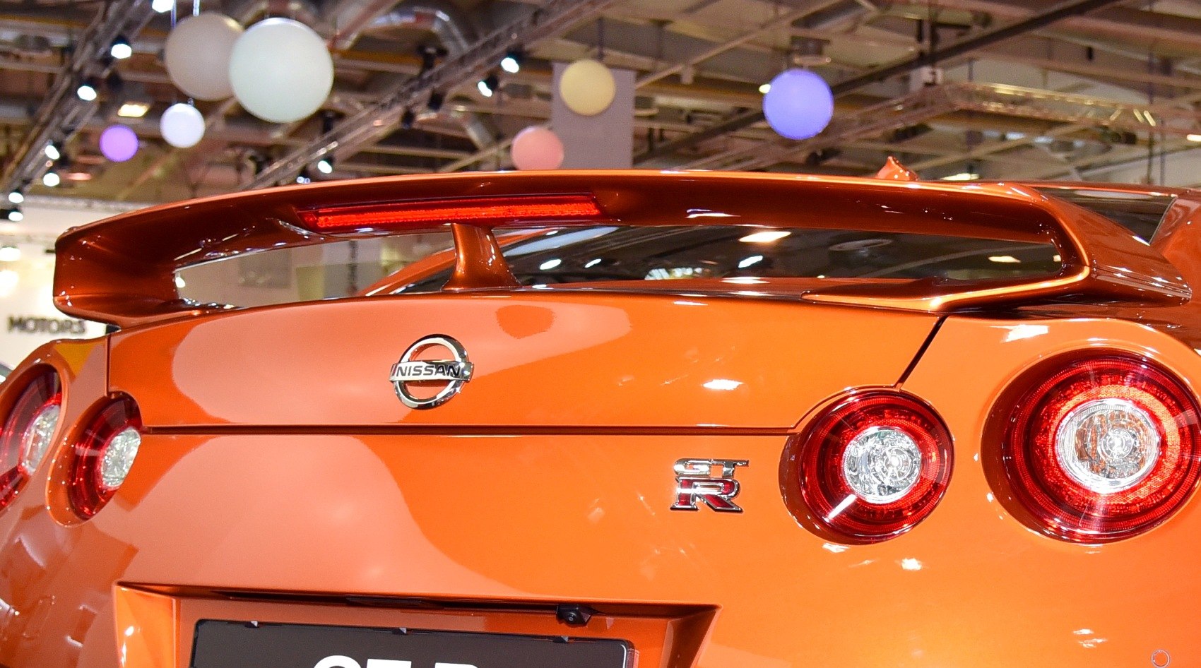 Rear spoiler and dual round taillights on an orange sports car