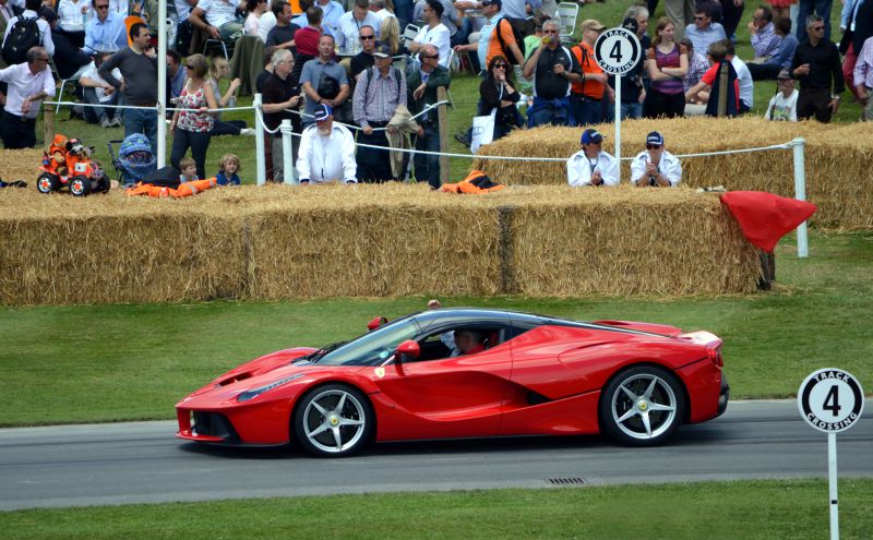 Sleek red sports car side profile with aerodynamic design and alloy wheels