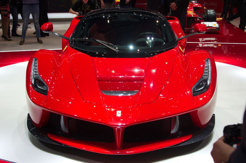 Aerodynamic front with LED headlights and low stance in red paint.