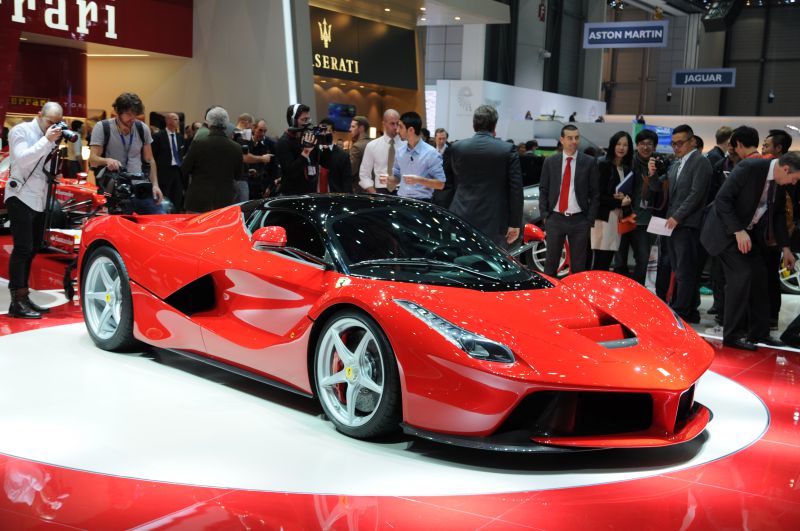 Aerodynamic red sports coupe with sharp headlights and sleek design.