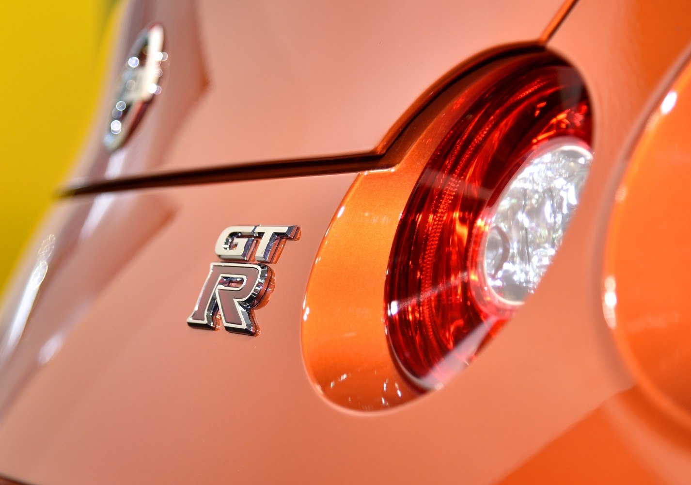 Close-up of rear GT-R badge and tail light on orange car