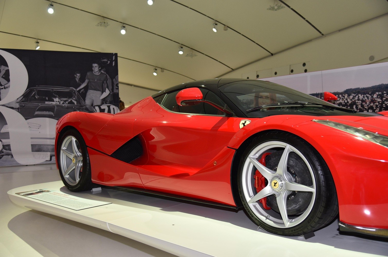 Red aerodynamic supercar side with black roof and unique five-spoke wheels
