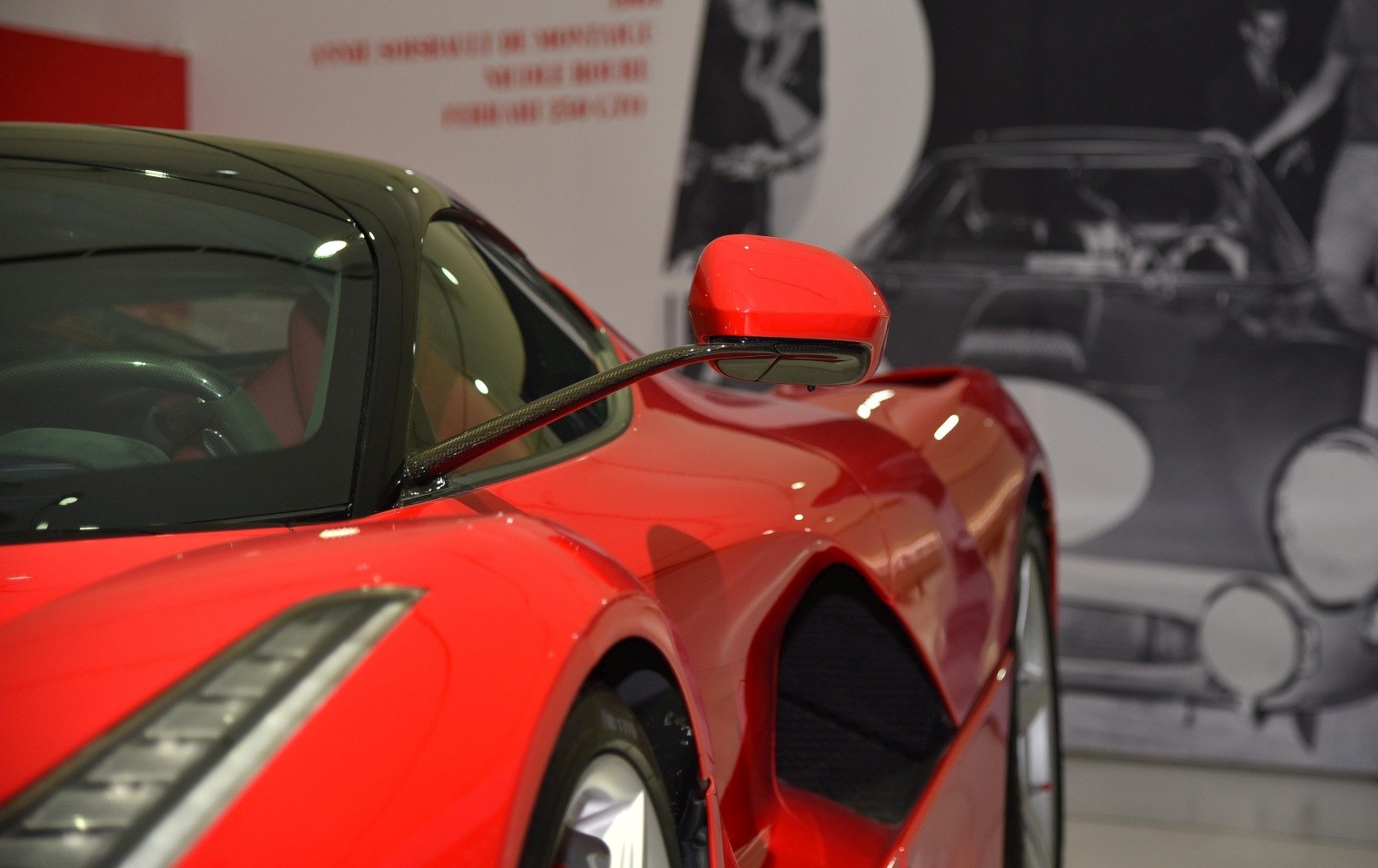 Close-up of red car’s side mirror and front fender with aerodynamic styling