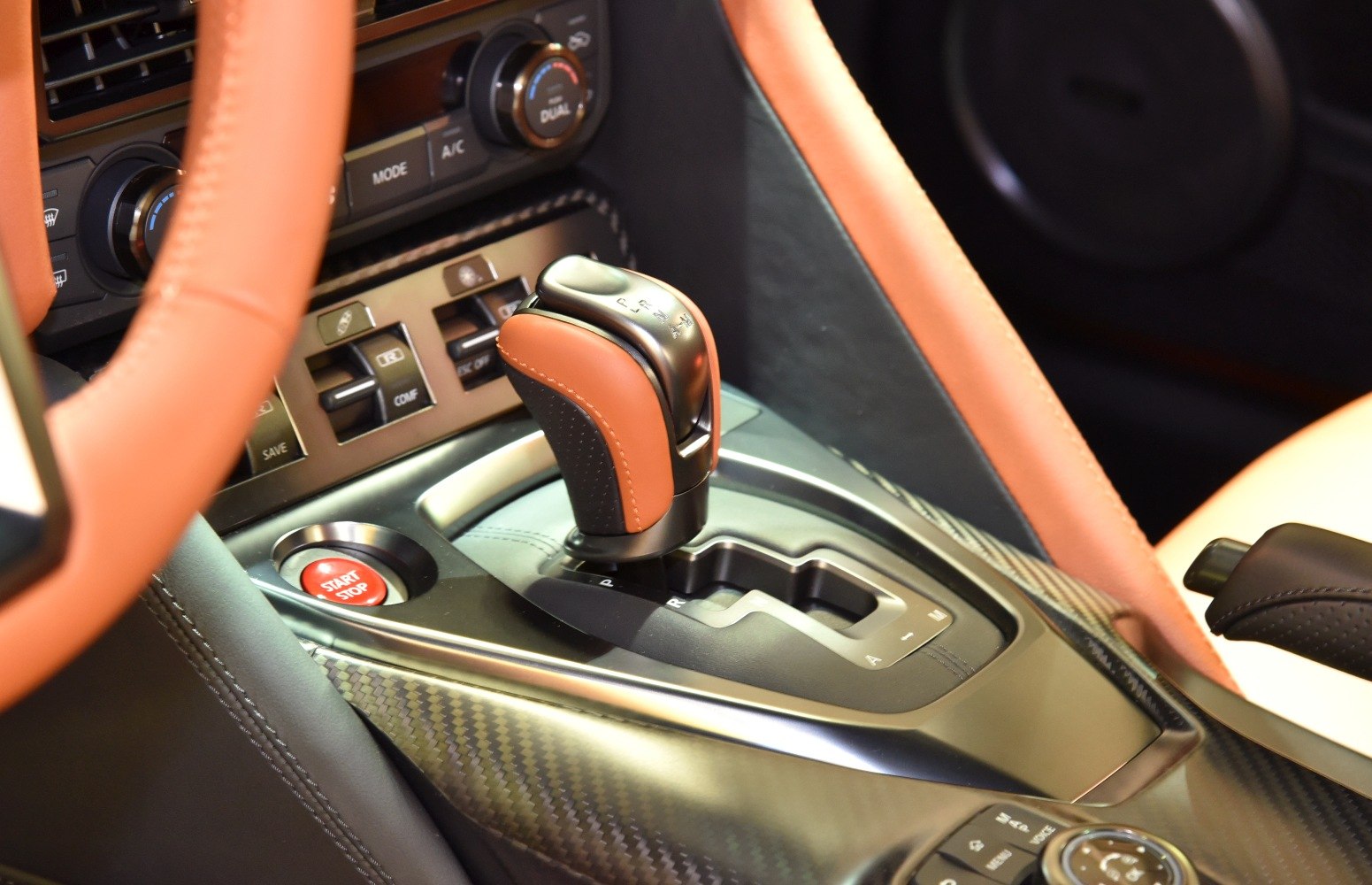 Close-up of gear shifter and start/stop button with carbon fiber trim