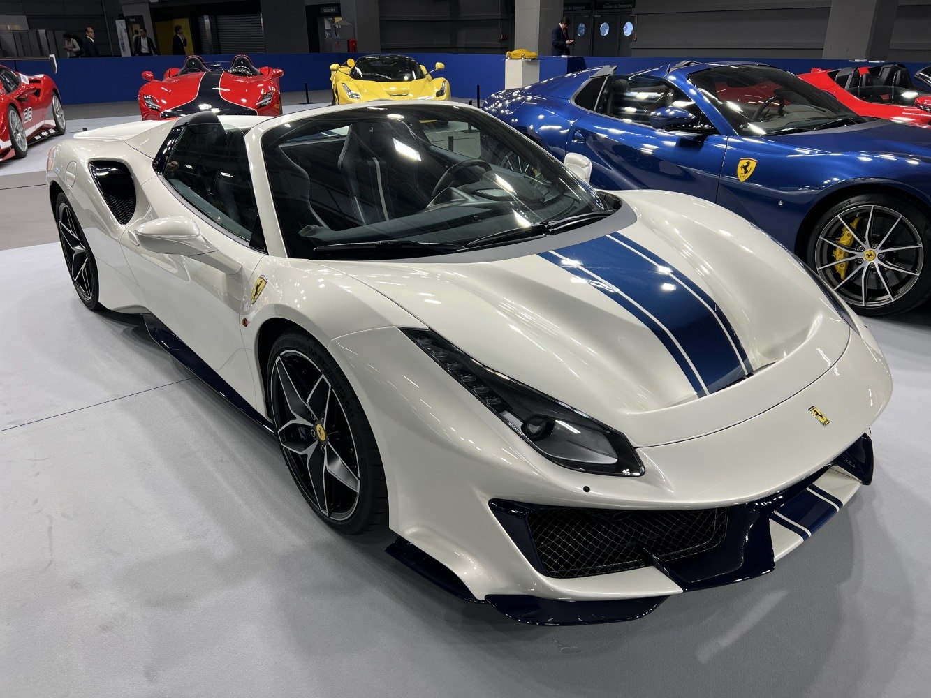 White convertible with blue racing stripe and aerodynamic front.