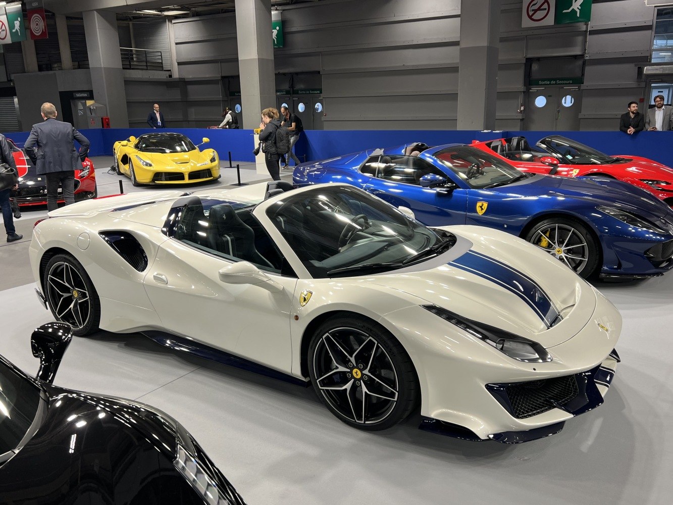 White convertible with blue racing stripe and aerodynamic design.