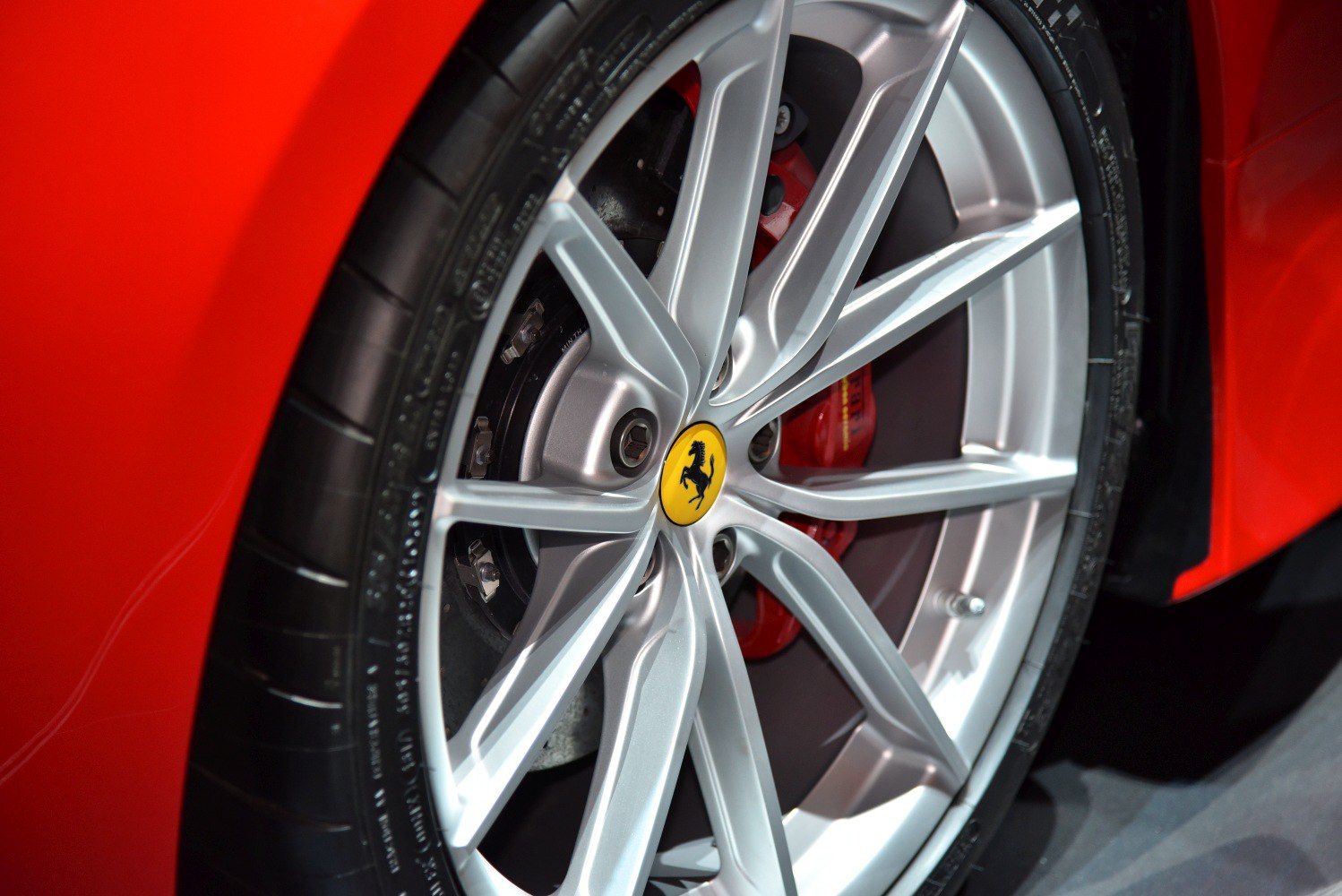 Sporty multi-spoke alloy wheel with red brake caliper and tire tread