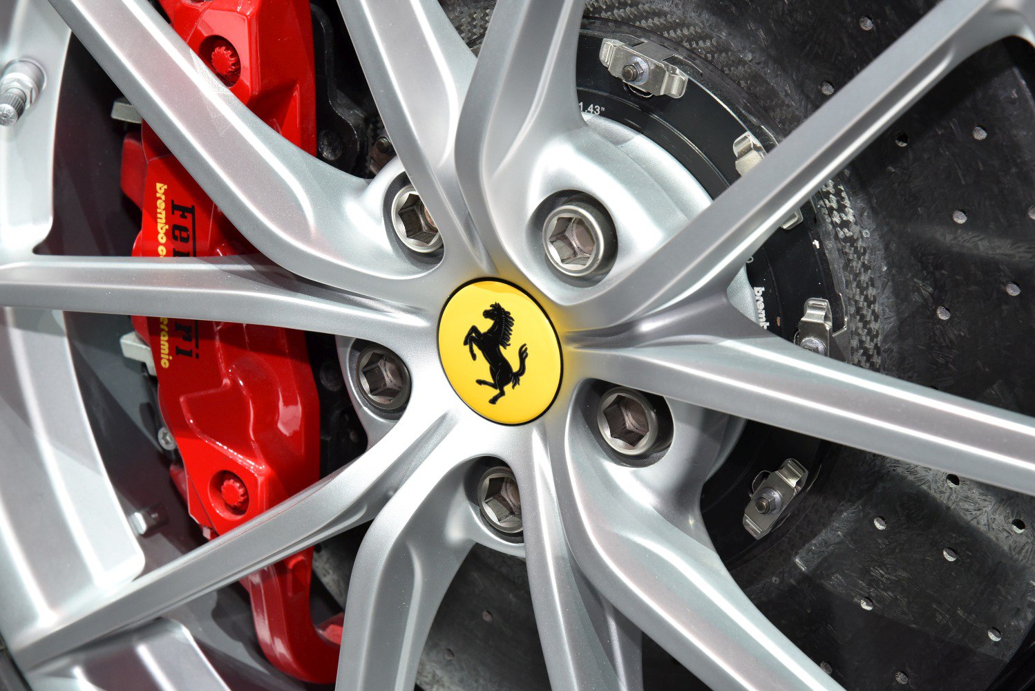 Silver alloy wheel with red Brembo carbon ceramic brake caliper