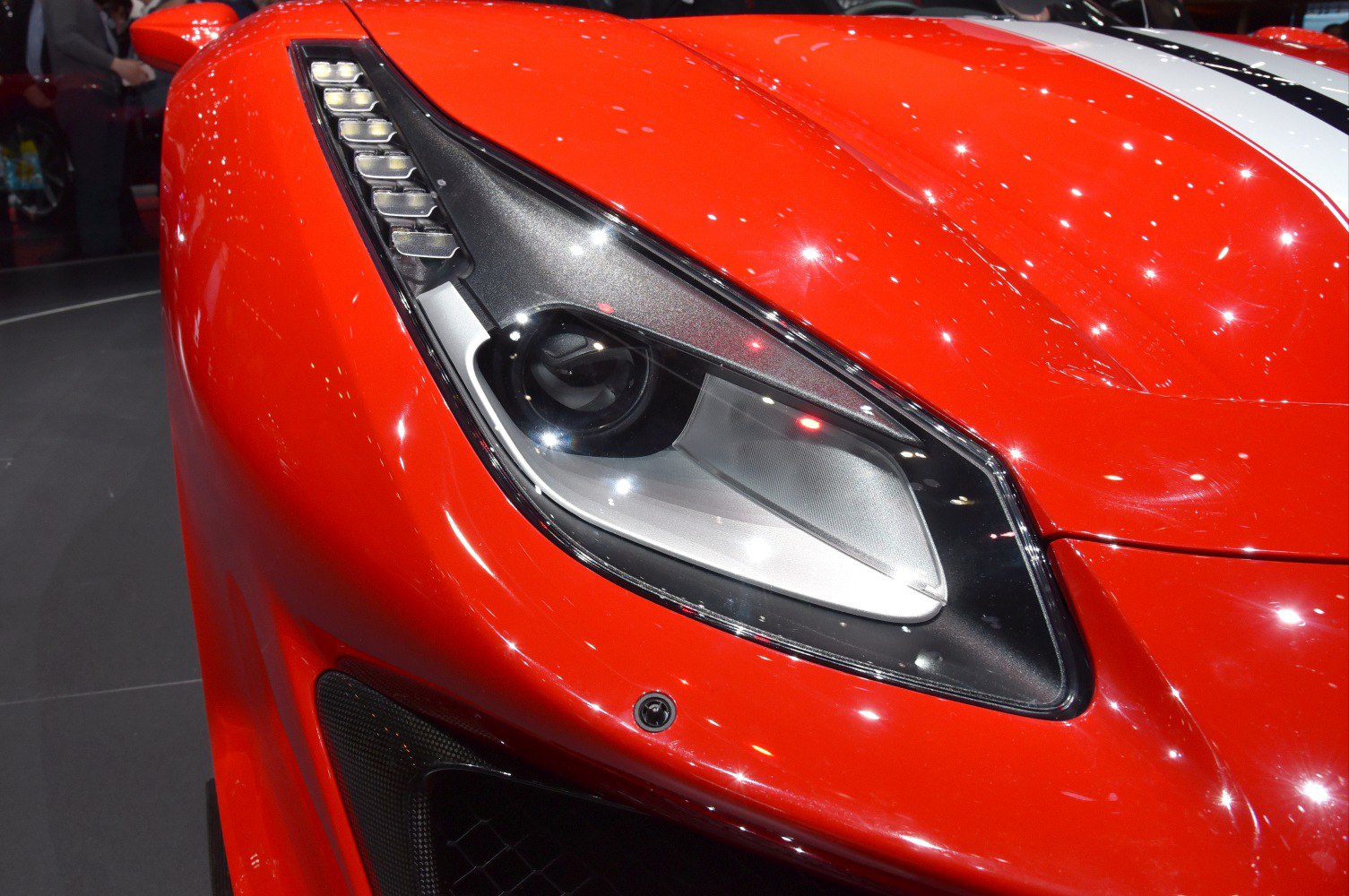 Close-up of a sleek sports car headlight with LED elements and aerodynamic front design