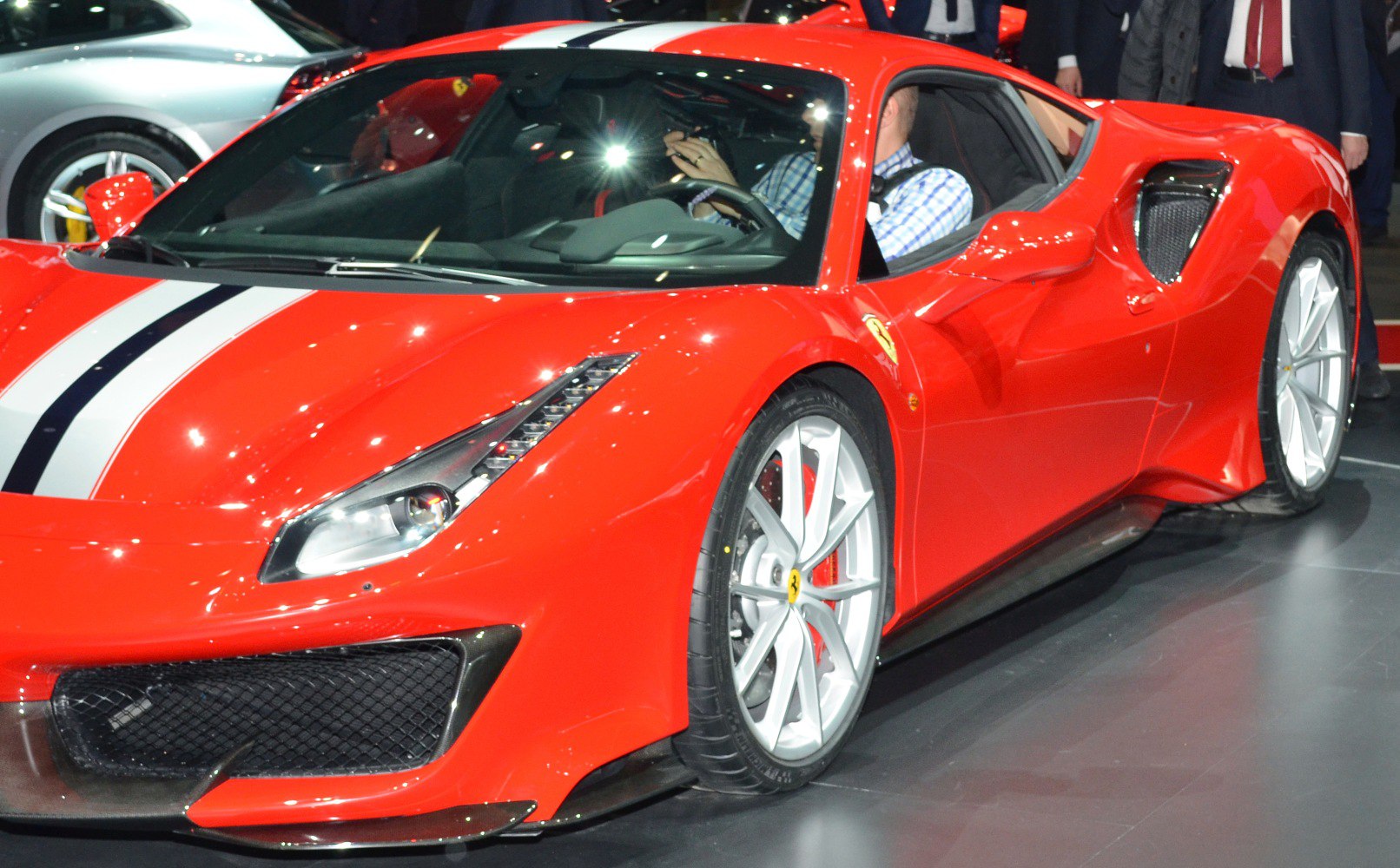 Front and side view of red sports car with racing stripes and aerodynamic details