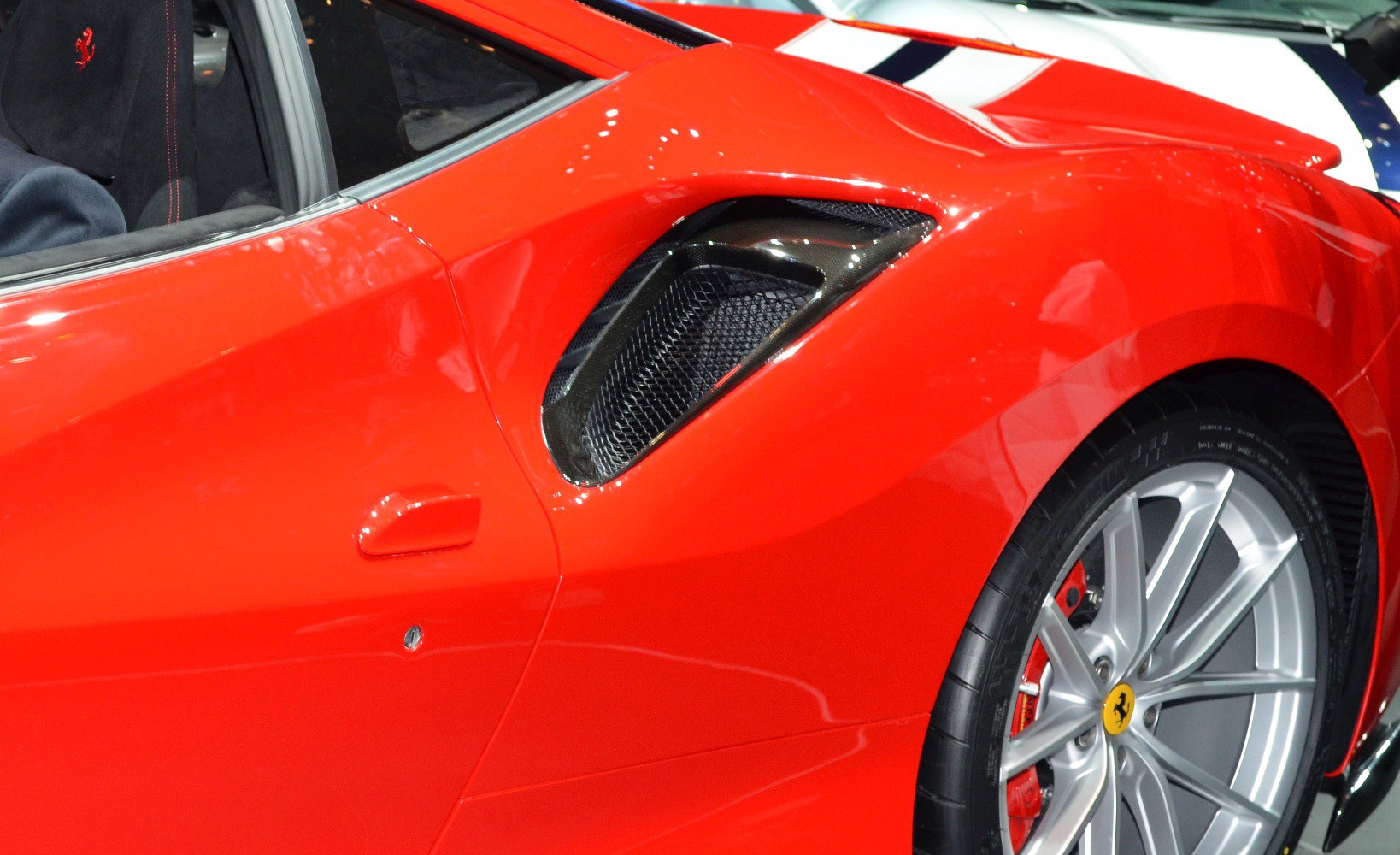 Side air intake vent and rear wheel with alloy rim and red brake caliper