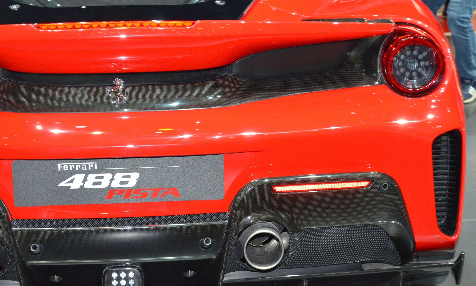 Close-up of rear taillight, exhaust, and carbon fiber diffuser