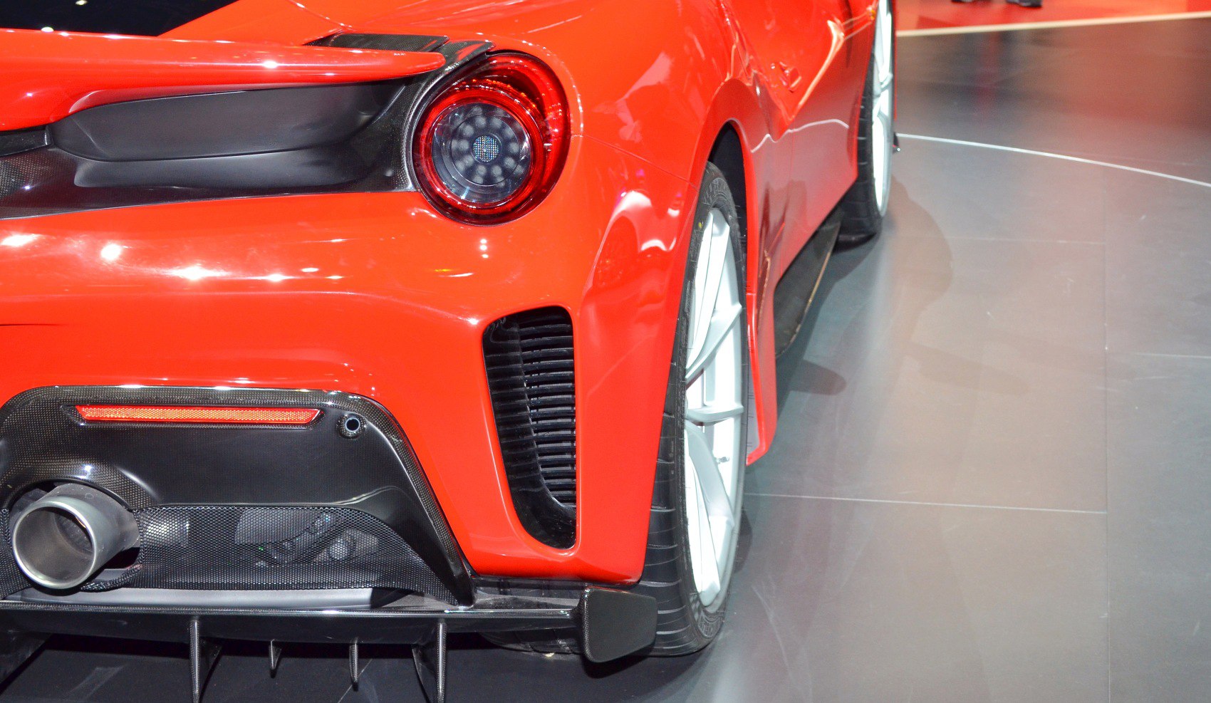 Red rear exhaust, tail light, and diffuser on a sports vehicle
