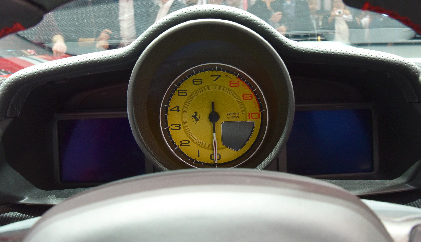Yellow tachometer with RPM gauge on a luxury sports car dashboard