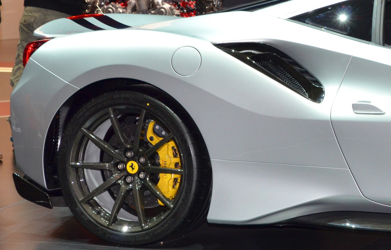 Rear wheel with carbon fiber rim and yellow brake caliper, aerodynamic side vent