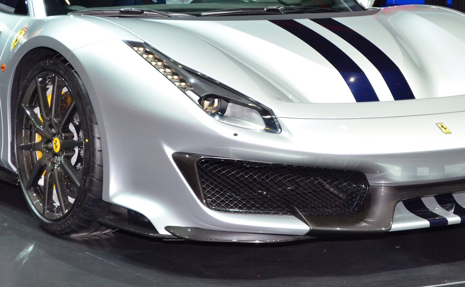 Front close-up of carbon fiber splitter and headlight with performance wheel.