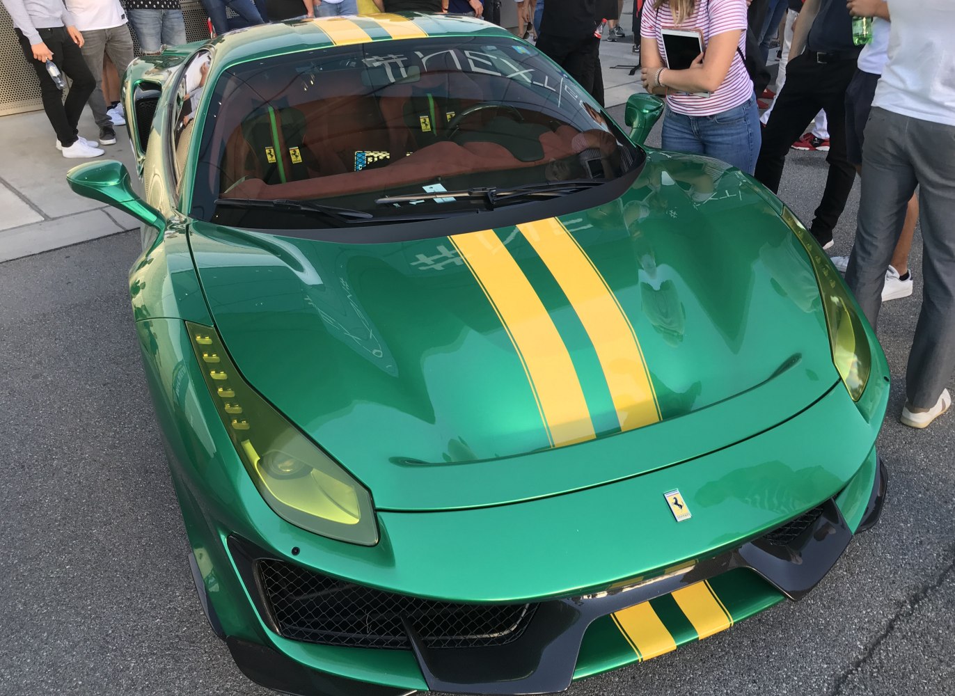 Green sports car front with yellow racing stripes and aerodynamic features