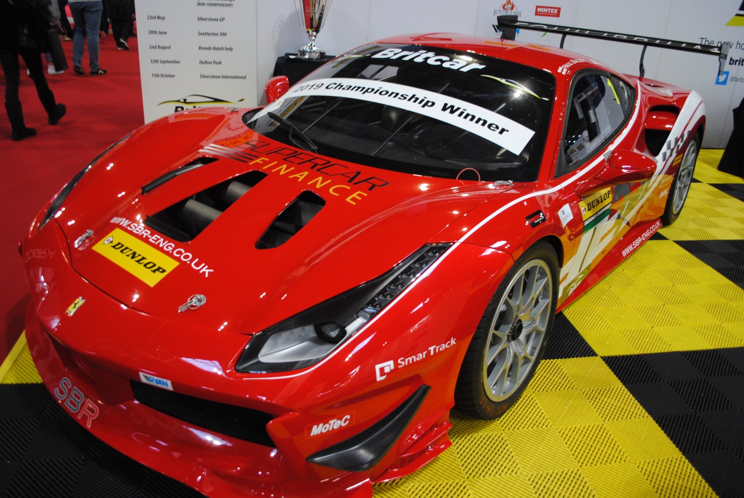 Red racing car with front vents and large rear wing