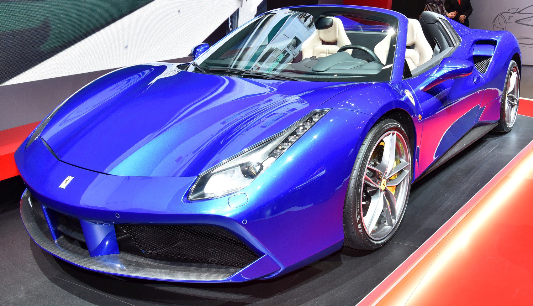 Close-up of convertible sports car front with sharp headlights.