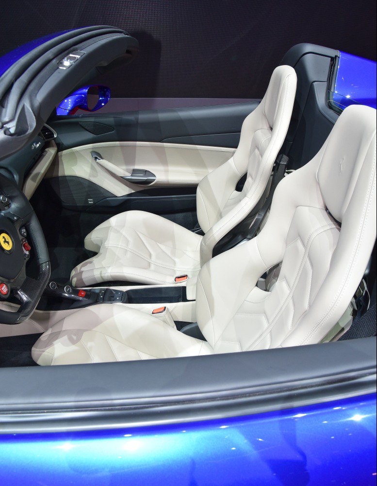 White leather bucket seats and carbon fiber trim in a sporty convertible interior