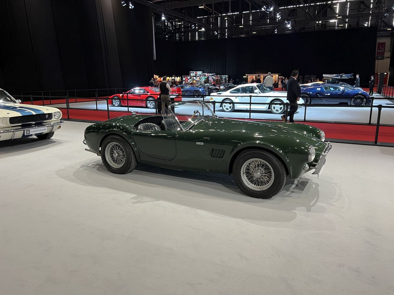 Dark green vintage open-top roadster with wire spoke wheels