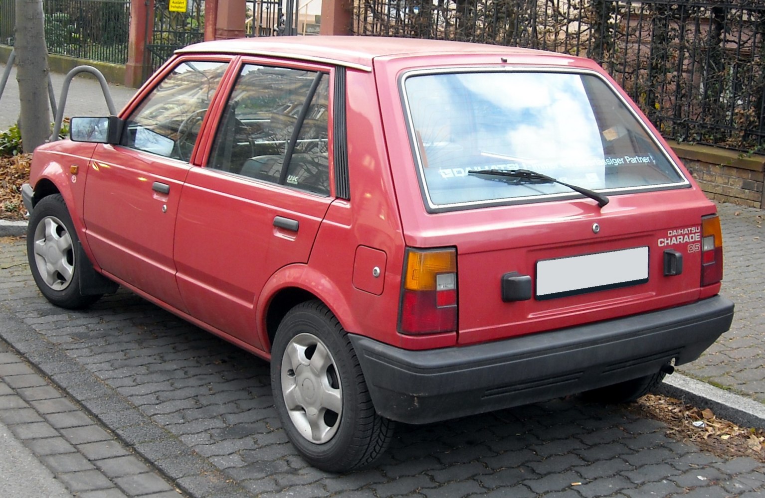 Vintage red hatchback rear with black bumper and distinct taillights