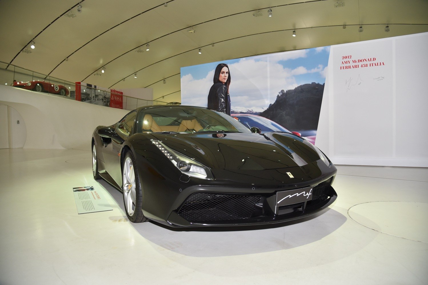Glossy black sports coupe front view with sleek aerodynamic design and distinctive headlights.