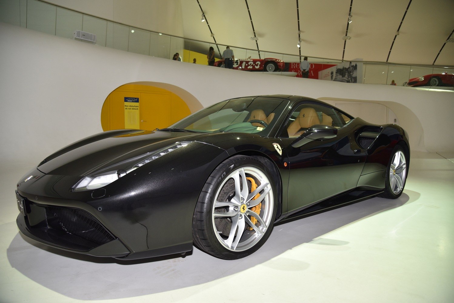 Sleek black sports coupe with silver alloy wheels and yellow brake calipers