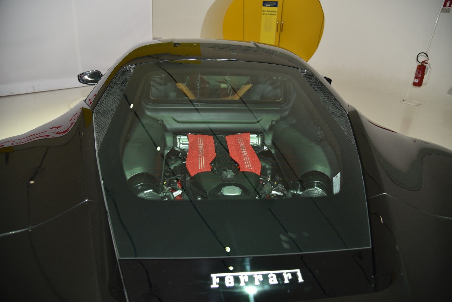 Mid-mounted engine with red intake covers visible through glass