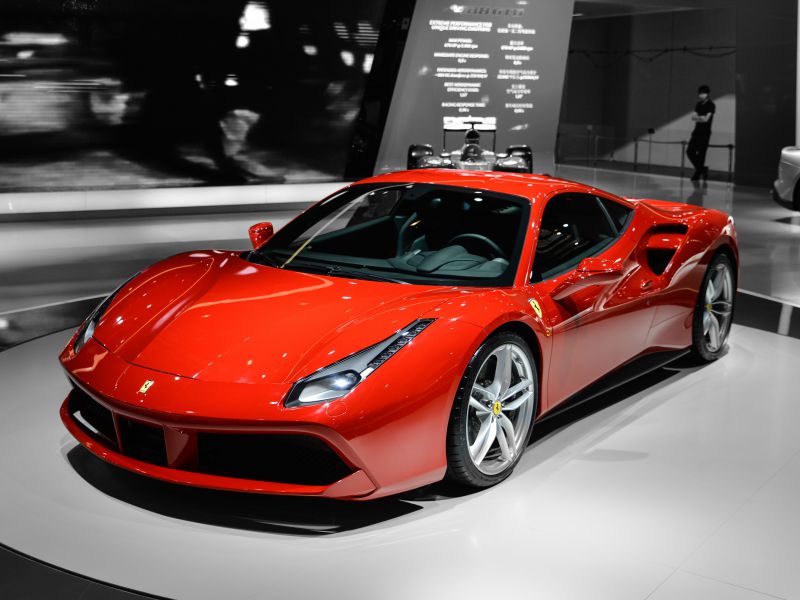 Red sports coupe with sleek headlights and aerodynamic design.