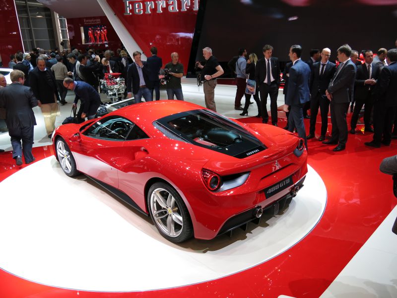 Rear view of red aerodynamic sports coupe with distinctive taillights and dual exhausts