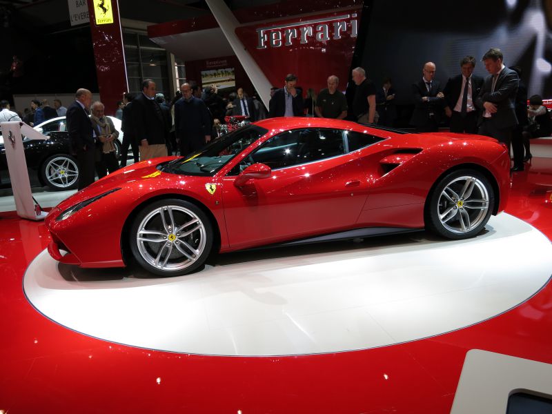 Side view of sleek red sports coupe with aerodynamic shape and alloy wheels