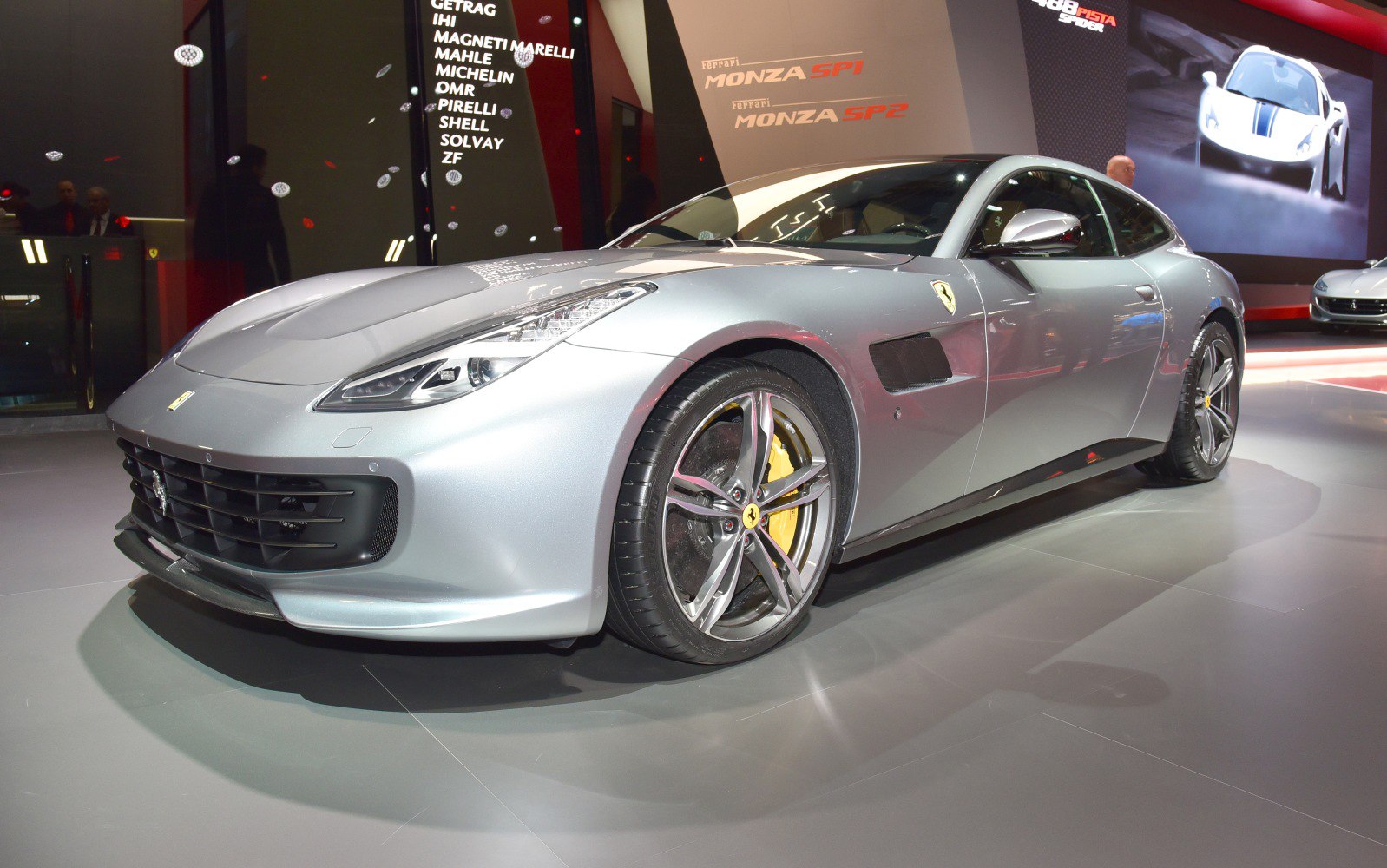 Front side view of sleek silver sports car with alloy wheels