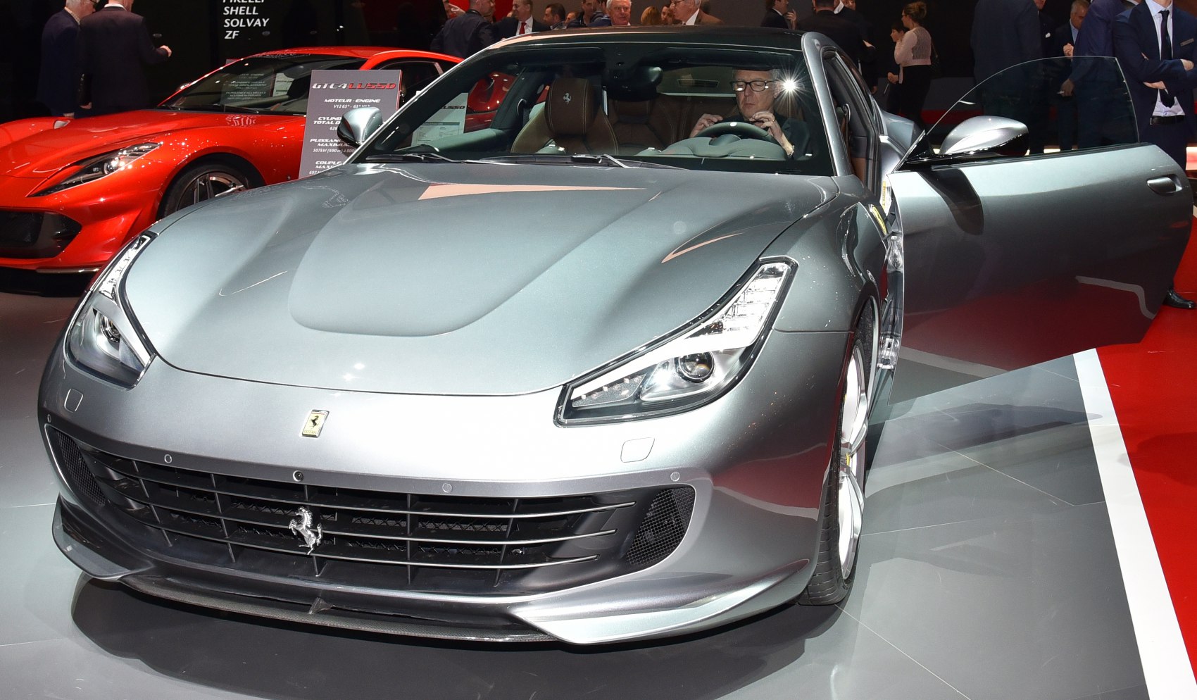 Front view of silver luxury vehicle with open door and modern headlights