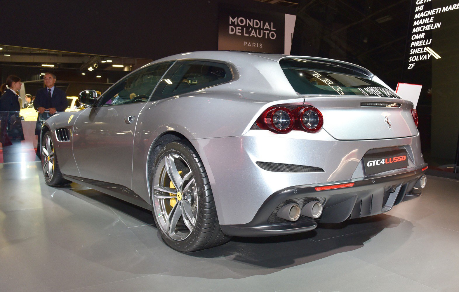 Silver sports car rear view with double circular taillights and quad exhausts