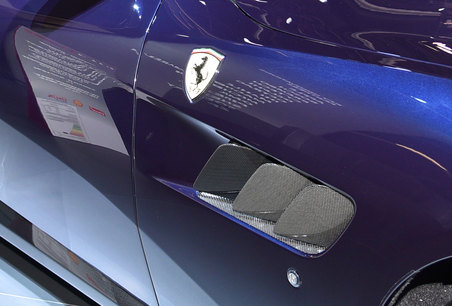 Side vent and Ferrari emblem on sleek dark blue car body