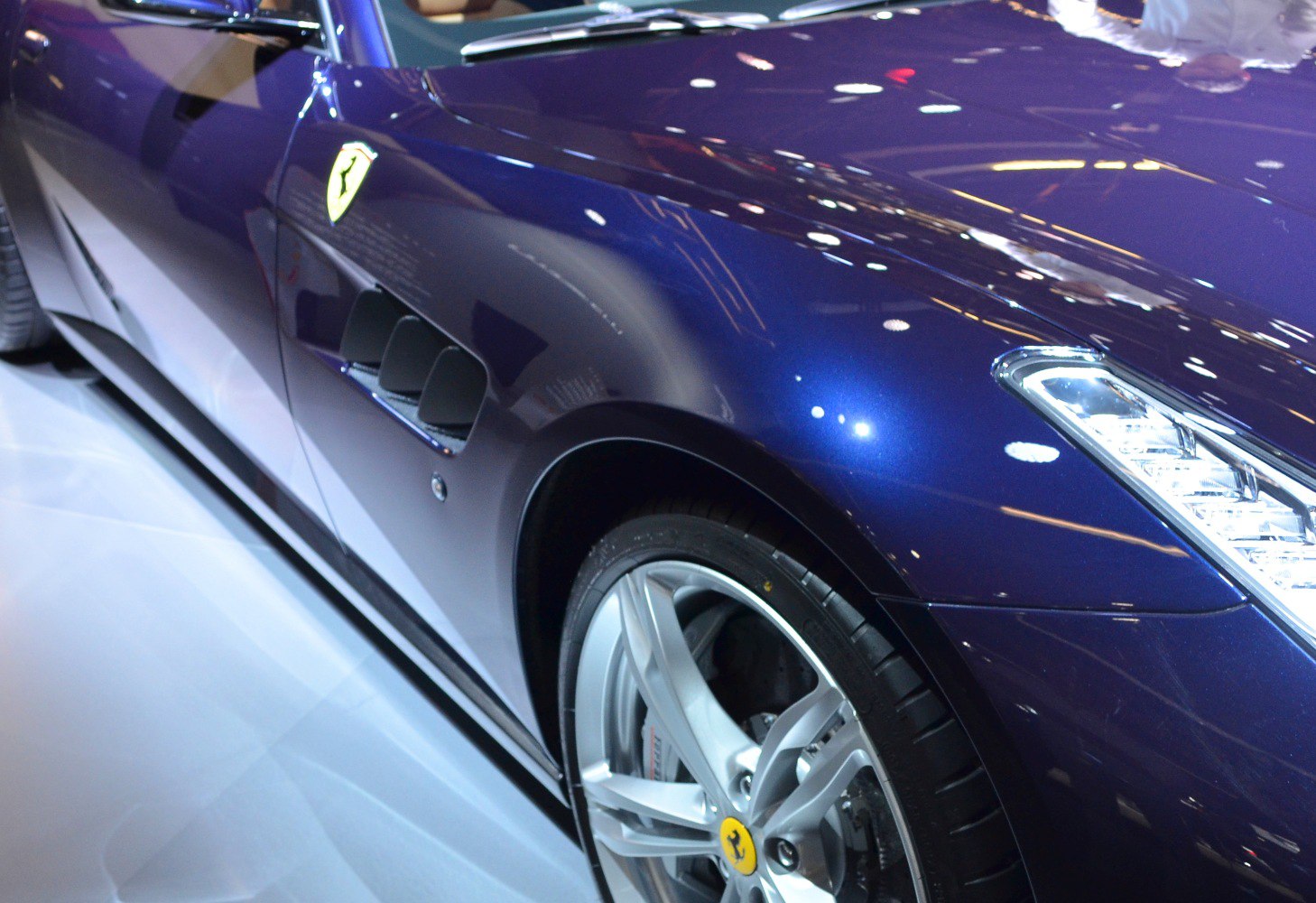 Close-up of side with alloy wheel, air vents, and headlight
