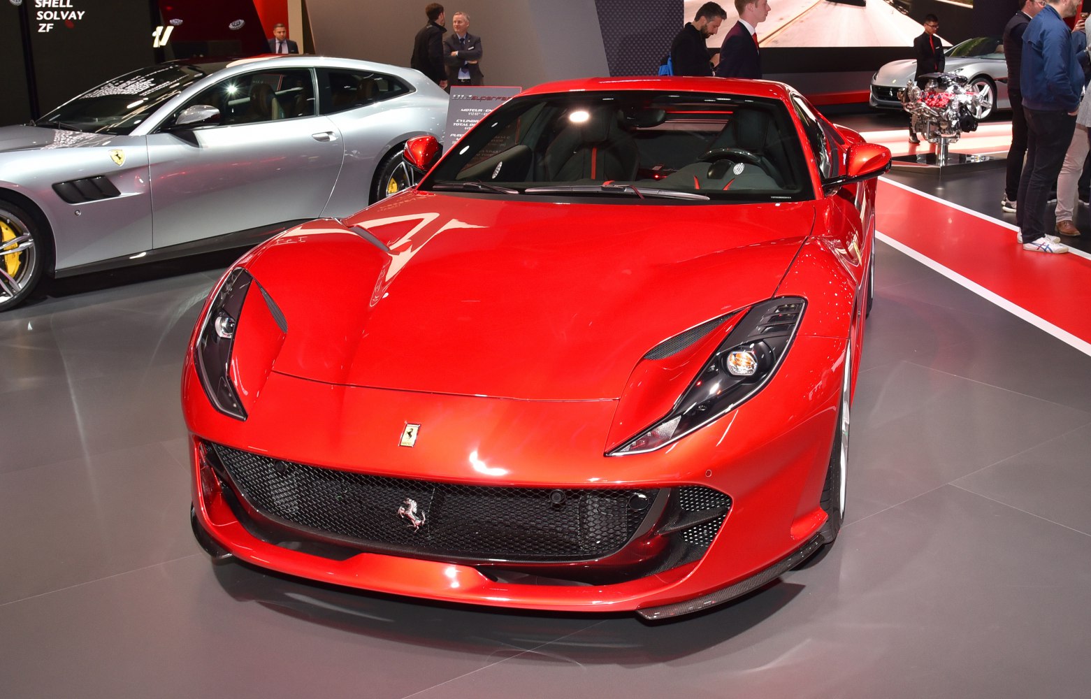 Red sports car front with aggressive headlights and mesh grille