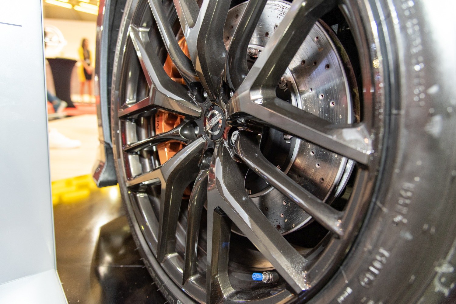 Close-up of alloy wheel and drilled brake disc with brake caliper
