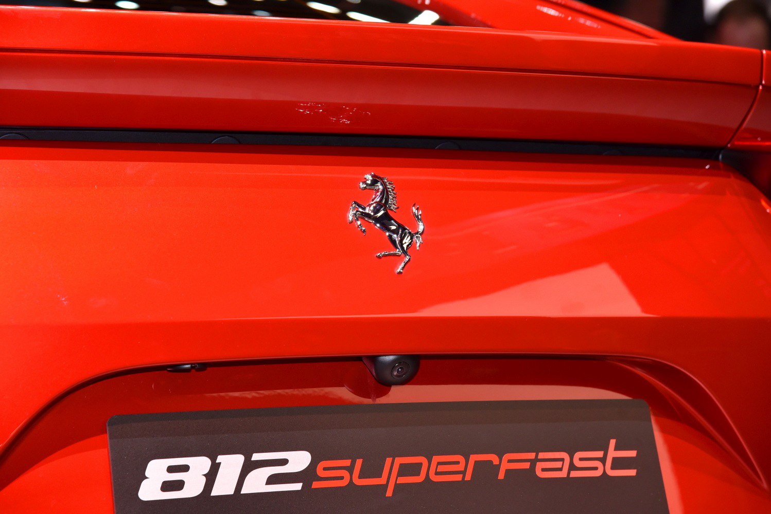 Close-up of Ferrari prancing horse emblem and 812 Superfast badge on red rear panel.
