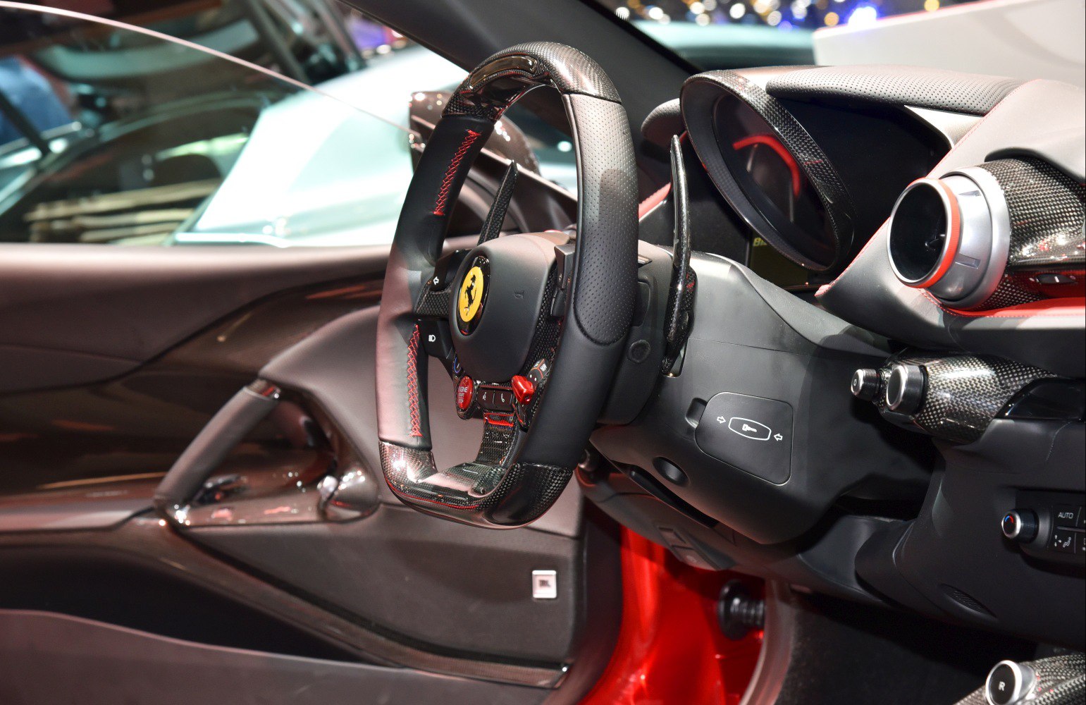 Carbon fiber steering wheel with red stitching and sporty dashboard