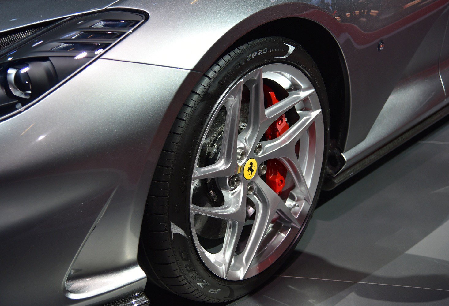 Silver alloy wheel with red brake caliper and front fender vent
