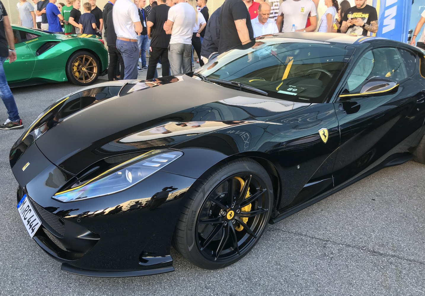 Glossy black vehicle front side with sporty alloy wheels and aerodynamic design lines