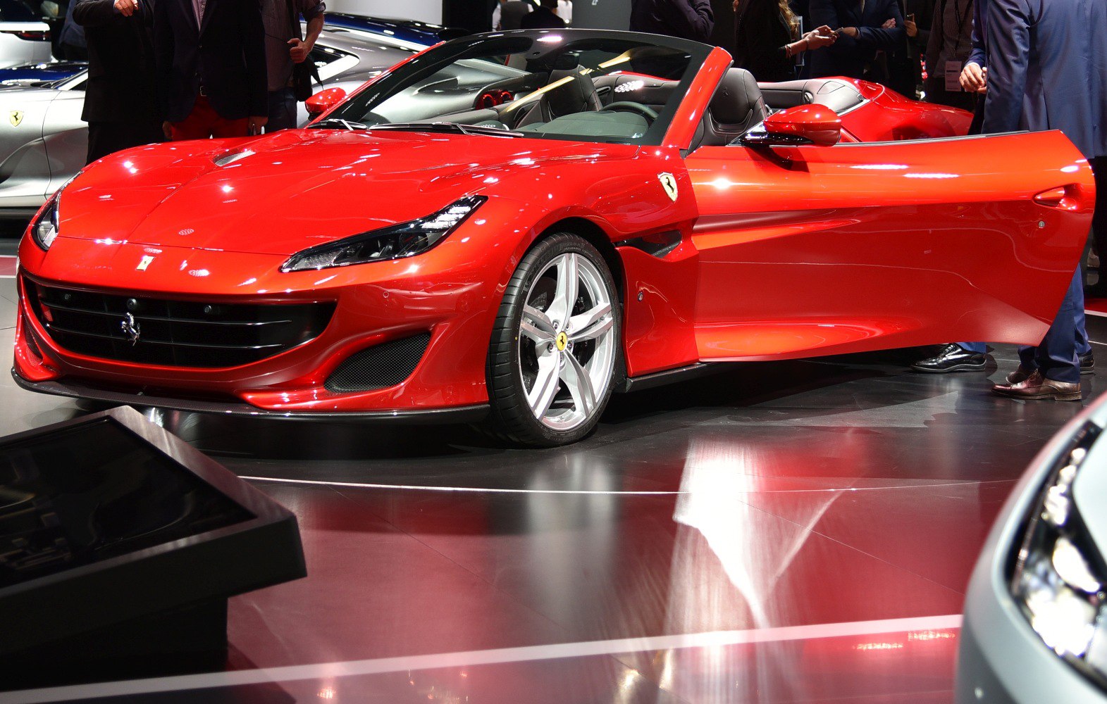 Red convertible sports car with open door and aerodynamic design