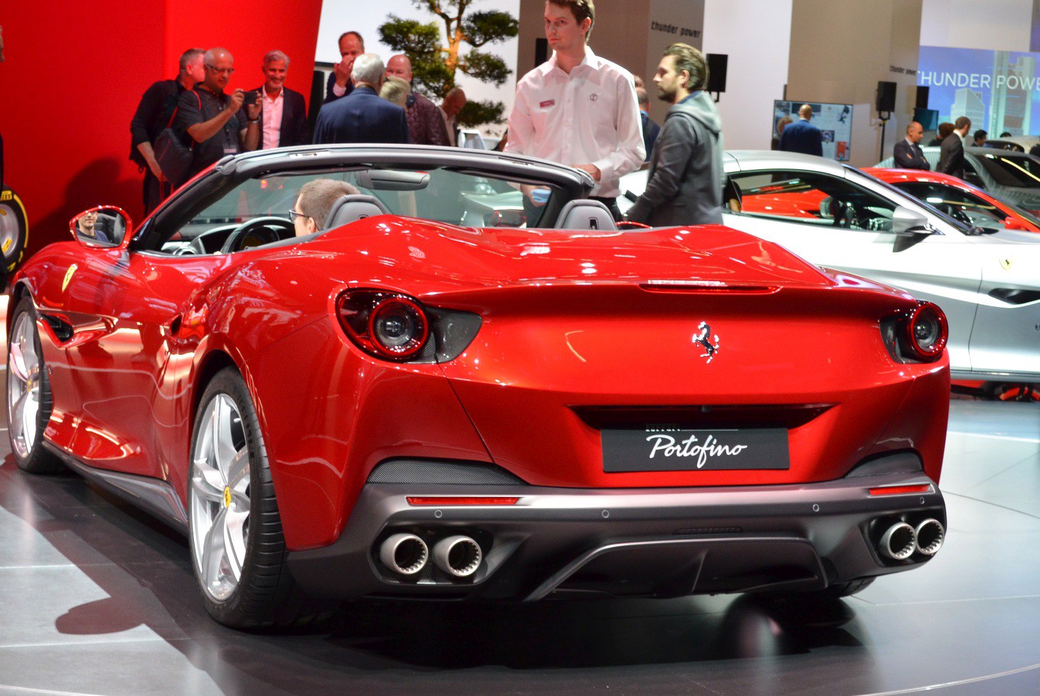 Red convertible car rear with twin exhausts and sleek tail lights