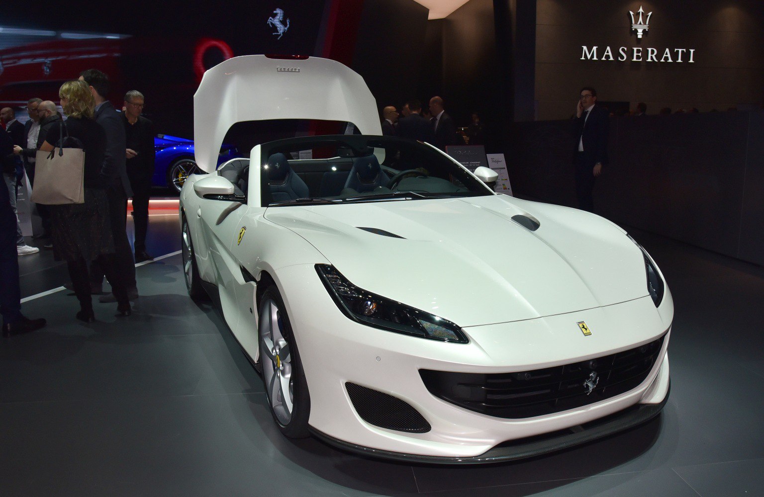 White convertible sports coupe with open trunk and sleek LED headlights